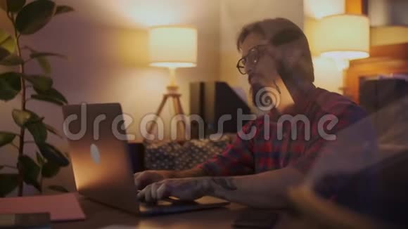 一个人在笔记本电脑上工作的工作的肖像商人深夜工作看着视频的预览图