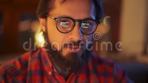 特写一位戴眼镜的大胡子年轻商人深夜在办公室工作的画像视频的预览图