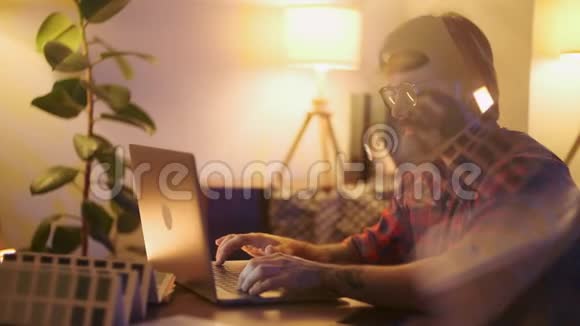 一位戴眼镜的大胡子建筑师深夜坐在办公室看监视器的画像视频的预览图