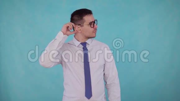 男人从耳朵里取出助听器听到蓝色背景视频的预览图