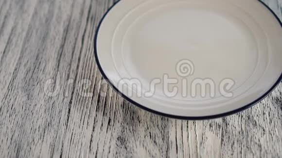 小麦面食落在白色盘子上蓝色的边框落在木桌上视频的预览图
