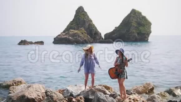 两个年轻的女人呆在索伦托的石岸上其中一个在跳舞视频的预览图