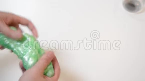 男人在白色背景下玩流行的黏液玩具黏液胶抗应力时间玩手工泥玩具的家伙视频的预览图