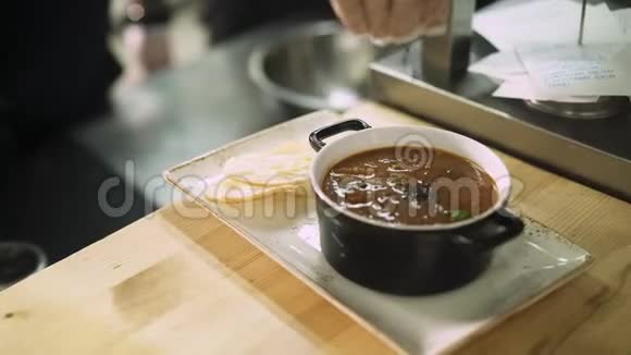 在厨房餐厅的桌子上端上一碗汤视频的预览图
