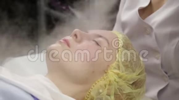 医生用蒸汽那个女人擦皮肤美容师皮肤有问题的年轻女人宇宙学概念视频的预览图