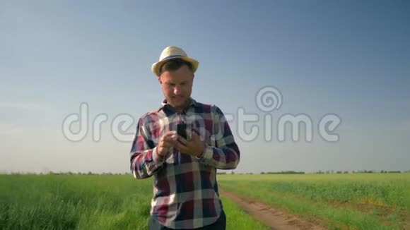 农夫带着快乐的情绪在手机上自拍然后在乡间散步时看着手机屏幕视频的预览图
