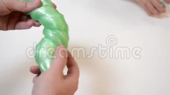 男人在白色背景下玩流行的黏液玩具黏液胶抗应力时间玩手工泥玩具的家伙视频的预览图