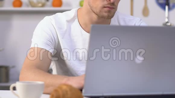 男人在笔记本电脑上工作喝咖啡妻子在准备晚餐时用电话视频的预览图