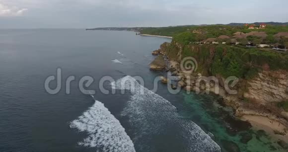 巴厘岛海岸的空中拍摄有悬崖和巨大的岩石多云4K视频的预览图
