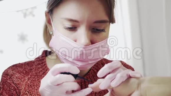 穿粉色医用口罩和手套的女孩美甲美容店视频的预览图