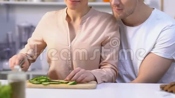 可爱的女孩喂心爱的男朋友蔬菜幸福的夫妻在厨房视频的预览图