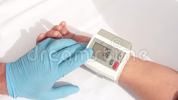 医生带着蓝色手套准备用数字血压计测量病人的血压和心率视频的预览图