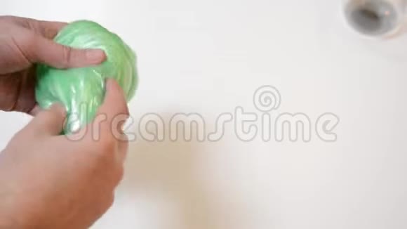 男人在白色背景下玩流行的黏液玩具黏液胶抗应力时间视频的预览图