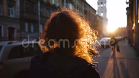 卷曲迷人的女孩微笑看起来很可爱日落时分欧洲城市的年轻美女穿蓝色衣服的女孩视频的预览图