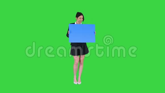 一个时尚的女人跳舞拿着空海报在绿色屏幕蓝色模型视频的预览图