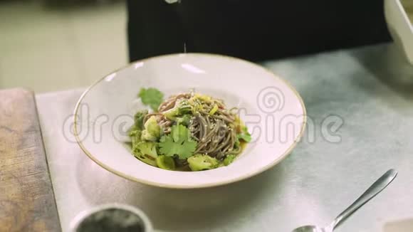 厨师用芝麻荞面装饰盘子视频的预览图