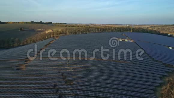 空中无人机镜头在秋天的日落季节太阳电池板农场的低空飞行视频的预览图
