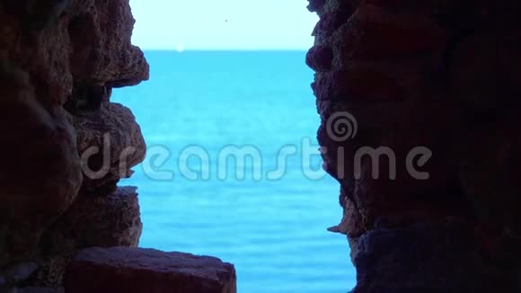 窗在一堵石墙上模糊的海景通向地平线视频的预览图