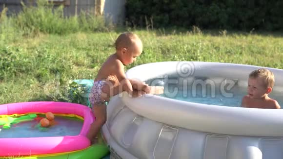 一个小男孩正在用水在充气游泳池里玩耍暑假和假期视频的预览图