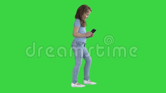 小女孩正在玩智能手机而走在绿色屏幕Chroma键视频的预览图