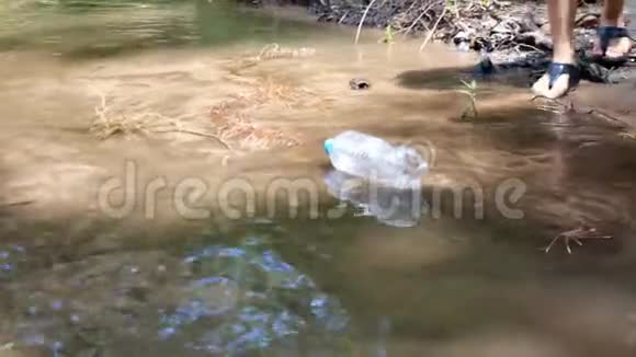 亚洲女人正在捡起漂浮在河岸上的塑料垃圾环境保护概念视频的预览图