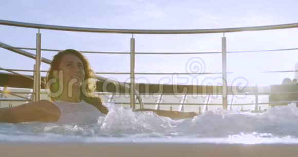 穿比基尼的年轻漂亮性感女人躺在按摩浴缸里视频的预览图