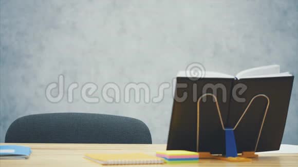 一个穿灰色衣服的女孩坐在桌子旁打开一本笔记本聪明专心的女学生做作业期间视频的预览图