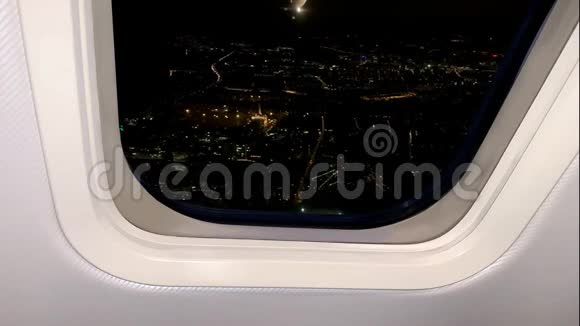 神秘的夜晚景观下面的黑暗城市明亮的灯光从飞机舷窗可以看到旅行的概念视频的预览图