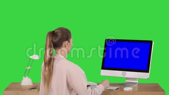 有吸引力的休闲女商人在办公室工作使用个人电脑蓝屏模拟显示在绿色屏幕色度键视频的预览图