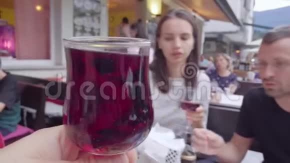 在餐馆吃午饭的时候一个人拿着杯和两个朋友碰杯视频的预览图