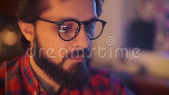 一个人在笔记本电脑上用眼镜工作的肖像关上门商人看监视器视频的预览图