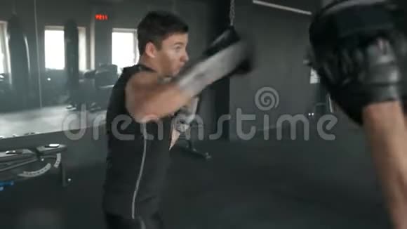 运动员在训练过程中与拳击教练在健身房打架4K50fps视频的预览图