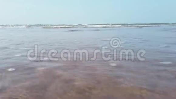 岸上的泡沫海波度假胜地阳光明媚的一天干净的海水在潮湿的沙滩上翻滚视频的预览图