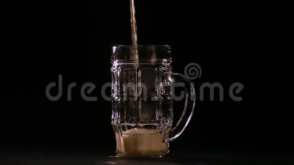 在啤酒杯里把啤酒倒在黑色的背景上视频的预览图