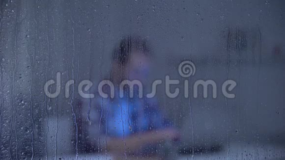 精疲力竭的中年男子在雨天用笔记本电脑工作逾期未交视频的预览图