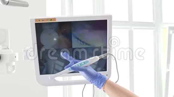 专业的女牙医用口腔内的方法在牙科椅上的一个年轻女孩的屏幕上显示她的手视频的预览图
