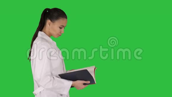 有吸引力的医学学生或医生与笔记本步行和阅读绿色屏幕铬键视频的预览图