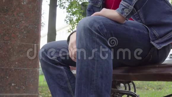 站在长凳上的人感到公园里膝盖剧痛骨关节炎受伤视频的预览图