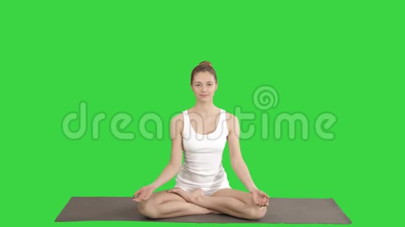 年轻漂亮的金发女人做瑜伽在绿色的屏幕上微笑铬钥匙视频的预览图