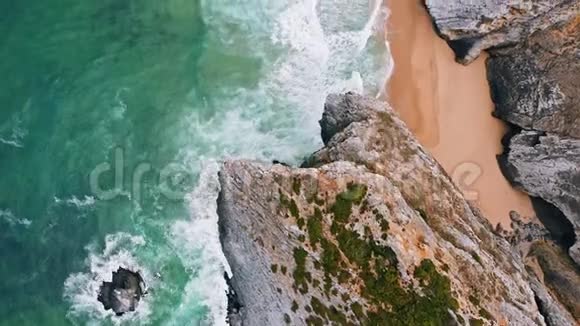 空中鸟眼飞越隐藏的普拉亚多卡瓦洛海滩在辛特拉葡萄牙白色波浪向海滩翻滚视频的预览图