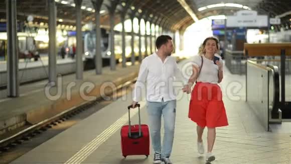 在火车站带西装革履的夫妇手里拿着护照的女人视频的预览图