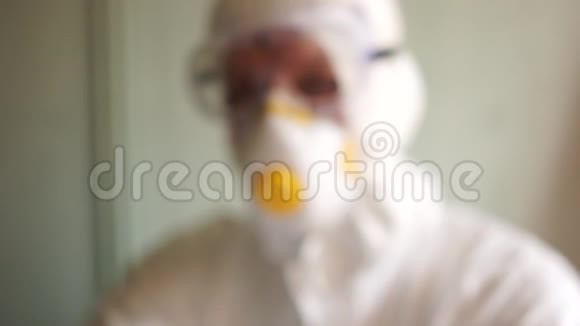 穿着防护服口罩和眼镜的男性科学家微生物学家手里拿着一个安瓿上面写着视频的预览图