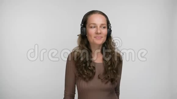 高兴的女人听着她最喜欢的一首关于智能手机跳舞和唱歌的歌一边欣赏音乐的肖像视频的预览图
