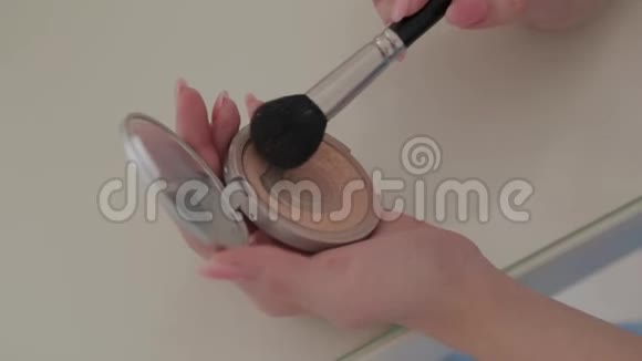 女性双手按住化妆刷在一个容器与粉末特写视频的预览图