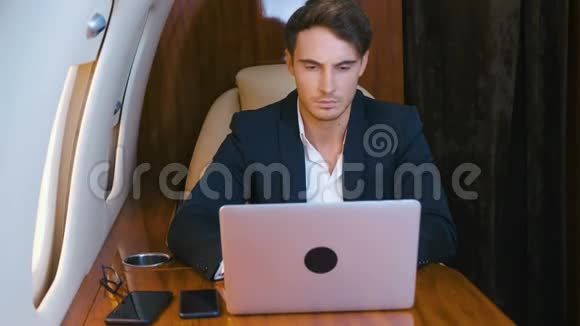 成功的百万人穿着古典西装使用笔记本电脑乘坐私人飞机旅行商人在这里工作视频的预览图