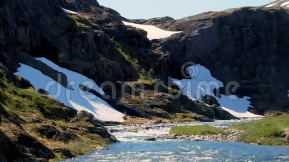 在一个阳光明媚的日子里挪威高山上积雪融化河水迅速流淌夹子右侧的热片视频的预览图