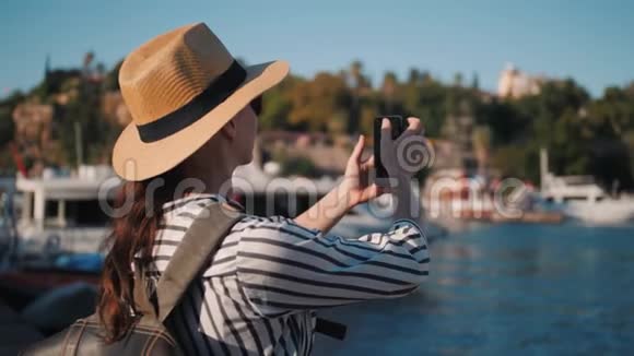穿着休闲装背包在码头拍照的千禧时髦女游客视频的预览图