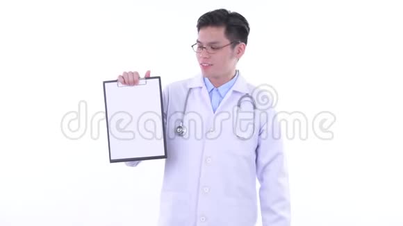 快乐的年轻亚洲男子医生展示剪贴板并竖起大拇指视频的预览图