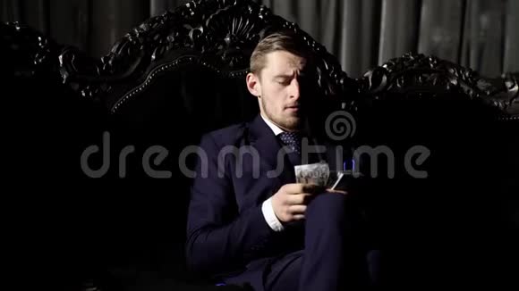 奢侈的生活理念穿西装的男人商人坐在黑暗豪华的室内背景奢华的生活方式视频的预览图