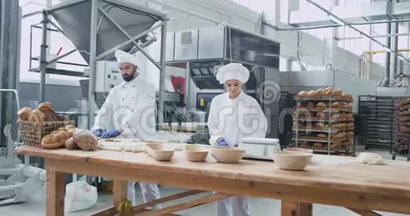 面包业专业面包师制作面团用有机面篮在餐桌上烤面包视频的预览图